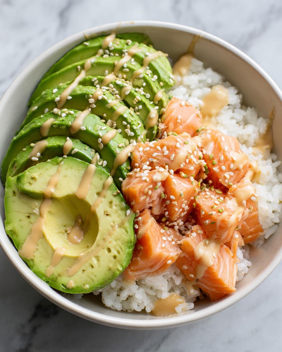 Nahaufnahme einer Avocado Bowl mit Lachs Reis, garniert mit Sesam und Sauce.