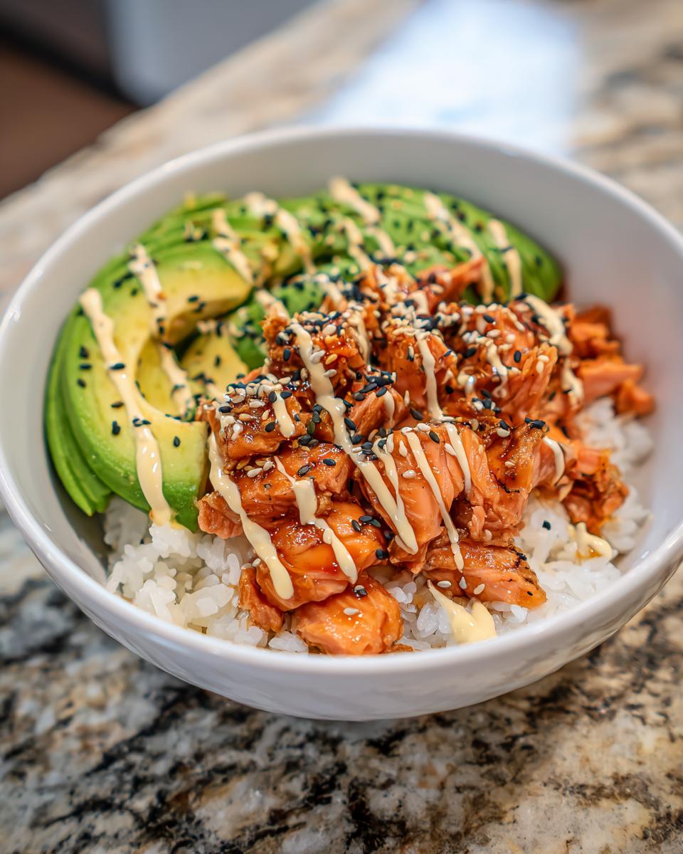 Nahaufnahme einer Avocado Bowl mit Lachs Reis, garniert mit Sesam und Sauce.